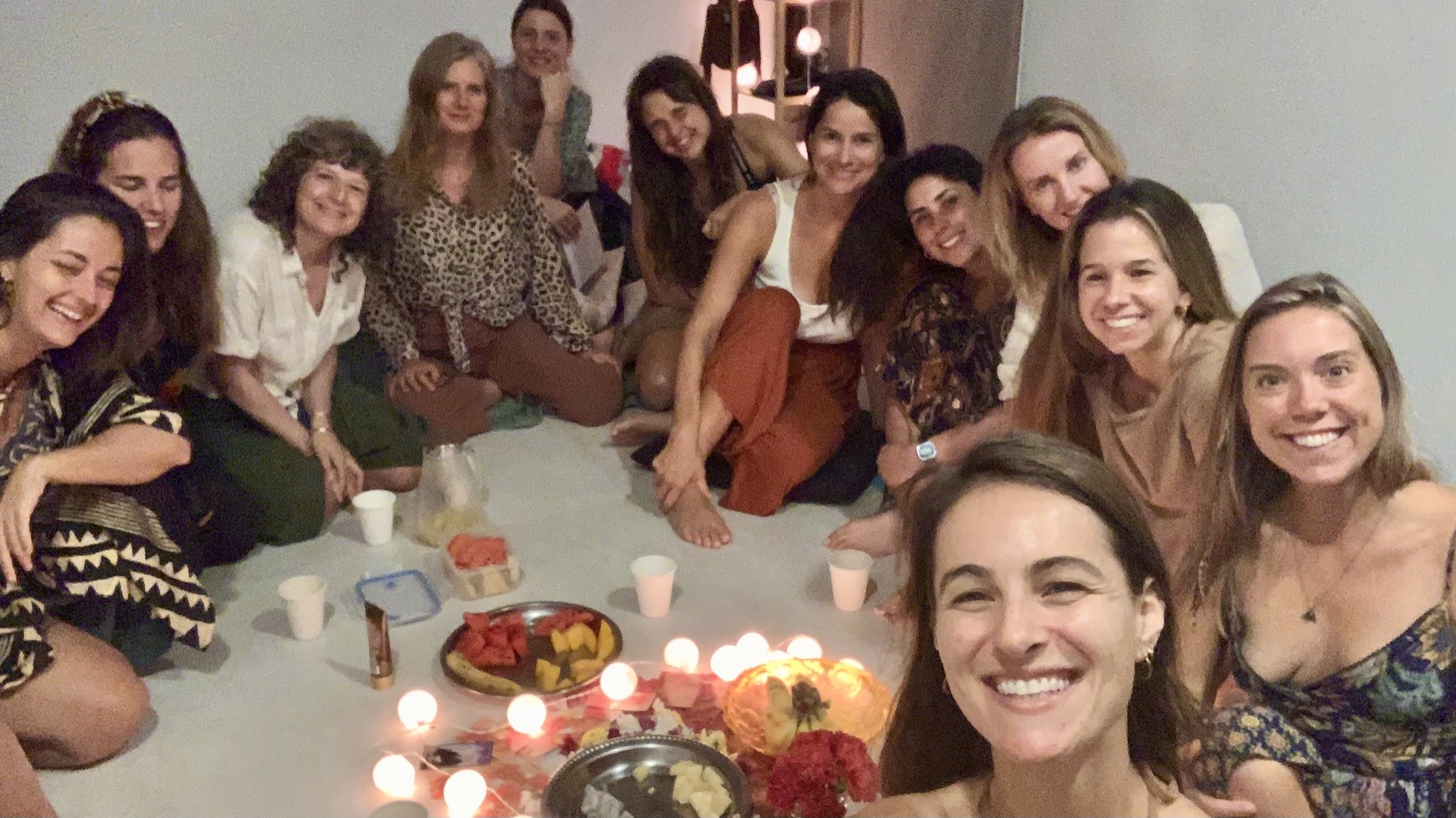 נשים סביב מרחב אינטימי עם נרות ופירות